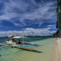 000104 Plage sur l'le de Coron Island  Palawan (Calamian Group, Philippines) avec au premier plan un trimaran (outrigger boat utilis par les pcheurs locaux). Ciel bleu et eau limpide avec une plage de sable compos de petits morceaux de coraux le tout surplomb par une imposante falaise de calcaire. Filtre polarisant.