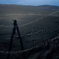 000161 Randonneurs sur les flancs de l'Etna (Sicile, Italie). Composition avec l'ombre du photographe. En arrire plan sentier en lacets parcouru par un minibus tout terrain convoyant des touristes. Ce sont ces-mmes minibus qui ont trac ce sentier qui va du refuge Sapienza (1990 m), dernier lieu de stationnement pour les cars et voitures, jusqu' Torre del Filosofo (ancien refuge qui marque l'arrt de cette piste,  2900 m). Au fond, la Sicile se dvoile. Photo ralise aprs l'ruption de 2002.