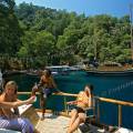 000176 Sur la cte mditerranenne turque, entre Fethiye et Kas, crique Tarzan's Bay o est amare une golette traditionnelle, appele gulet. Touristes plaisanciers s'adonnant au farniente en premier plan. Filtre polarisant.