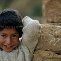 000401 Portrait d'un gamin devant un mur en briques d'adobe dans la banlieue de Cuzco (Prou).