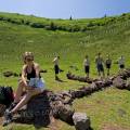 000644 Randonneuse assise et groupe de scouts formant une croix scoute  l'aide de grosses pierres dans le cratre du Puy de Pariou (Puy-de-Dme (63), France).