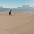 000904 Jeune femme pratiquant des tirements sur la plage d'Hossegor (40150) (Landes (40), France). Prise de vue en hiver.