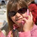 001076 Fillette jouant avec un faux tlphone portable et arborant les lunettes de soleil de sa mre.