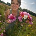 001436 Jeune femme souriante tenant un bouquet de fleurs champtre (Puy-de-Dme (63), France). Image ralise dans une jachre fleurie cre  l'initiative des fdrations de chasseurs et des agriculteurs locaux. Ce type de jachre en plus d'amliorer les paysages, favorise la biodiversit et offre un refuge et des sources de nourriture  une faune varie : abeilles, araignes, papillons, et mme petits mammifres et oiseaux.
