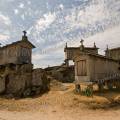 001502 Les espigueiros sont des constructions sur pilotis faisant office de grenier  grains. Ils permettent d'abriter, de scher et de conserver les rcoltes sous le climat humide de la bordure atlantique. Ces abris dresss sur leurs pieds les loignant du sol et les protgeant des rongeurs, sont exposs au soleil et au vent. Ils reposent souvent sur une dalle rocheuse de granit qui sert d'aire de battage, mais permet aussi d'accumuler la chaleur du soleil dans la journe et de la restituer la nuit. Il s'agit ici des espigueiros de Soajo, village du Haut-Minho dans le Parc naturel de la Serra da Estrela (Porto e Norte de Portugal, Portugal).