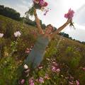 001686 Jeune femme souriante brandissant des bouquets de fleurs champtres (Puy-de-Dme (63), France). Image ralise dans une jachre fleurie cre  l'initiative des fdrations de chasseurs et des agriculteurs locaux. Ce type de jachre en plus d'amliorer les paysages, favorise la biodiversit et offre un refuge et des sources de nourriture  une faune varie.