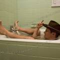 001776 Homme coiff d'un chapeau de cowboy prenant un bain dans une petite baignoire sabot.