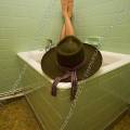 001777 Homme coiff d'un chapeau de cowboy prenant un bain dans une petite baignoire sabot.