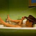 001779 Homme coiff d'un chapeau de cowboy prenant un bain dans une petite baignoire sabot.